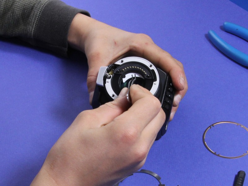 White contact-block shim being inserted beneath electrical contacts